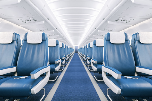 Interior of a commercial airplane cabin with blue leather seats. Interior of a commercial airplane cabin with blue leather seats.